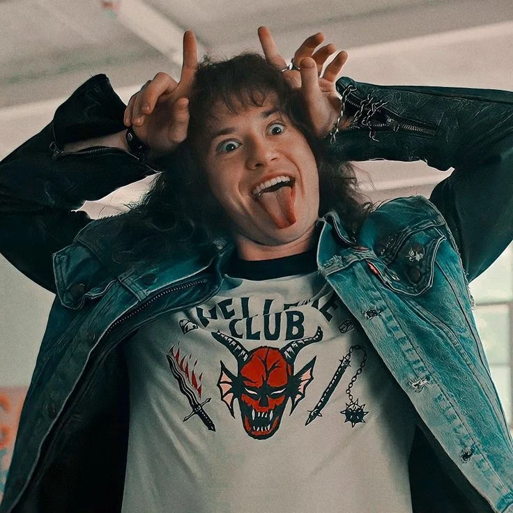 Eddie Munson pulling a face with his hands above his head