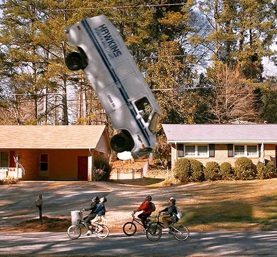 A government van thrown into the air above four children on bicycles